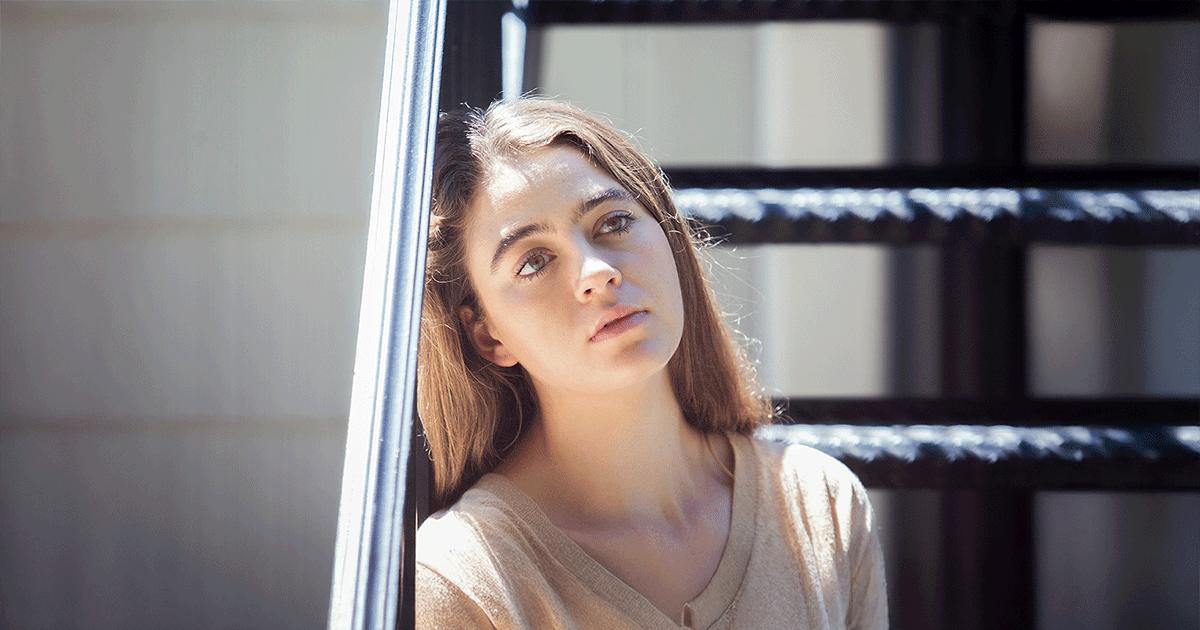AdobeStock_313941055-blog Woman reflecting on the emotional impact of a pregnancy decision while sitting alone outdoors.